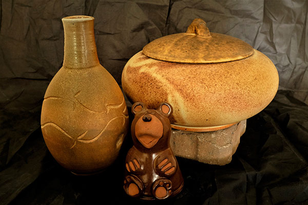 two pottery jars and pottery bear cub