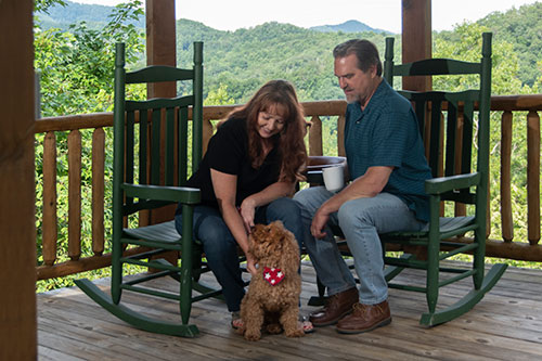 Pet-friendly-cabin couple with dog on porch